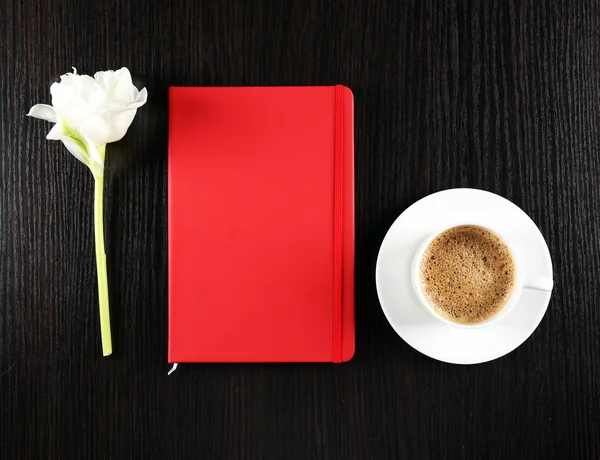 Kopje koffie met notebook en verse bloemen op houten tafel achtergrond — Stockfoto