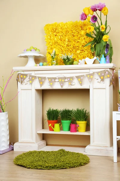 Fireplace with beautiful spring decorations in room — Stock Photo, Image