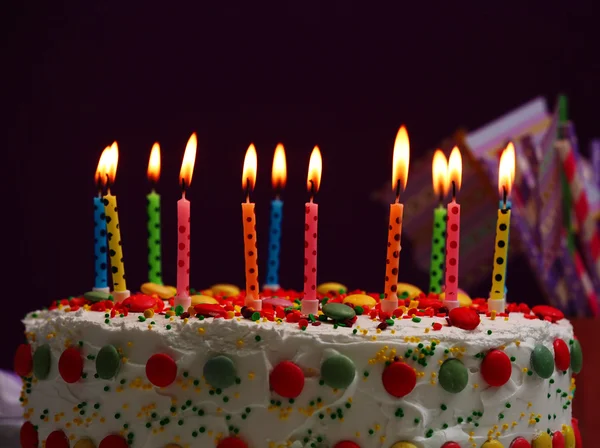 Bolo de aniversário com velas no fundo roxo — Fotografia de Stock