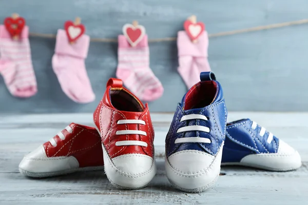 Lindos zapatos para niños pequeños y calcetines sobre fondo de madera —  Fotos de Stock