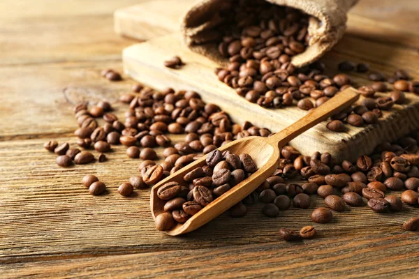 Grains de café sur table en bois, gros plan — Photo