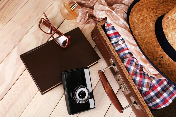 Упаковка валізи для поїздки на дерев'яному фоні — стокове фото