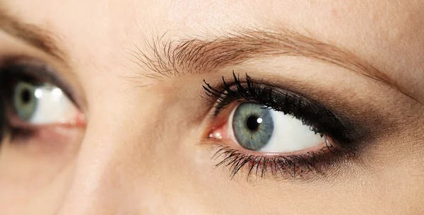 Глаз молодой женщины со слезоточивой каплей вблизи — стоковое фото