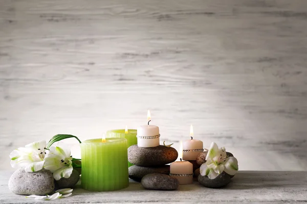 Hermosa composición con velas y piedras de spa sobre fondo de madera — Foto de Stock
