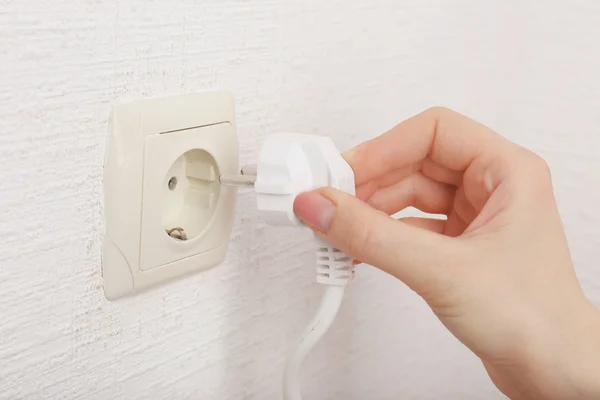 Hand putting plug in electricity socket — Stock Photo, Image