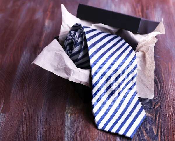 Corbata a rayas en caja sobre fondo de madera — Foto de Stock