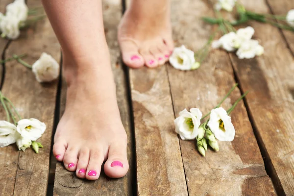 Mooie vrouwelijke benen op rustieke houten vloer achtergrond — Stockfoto