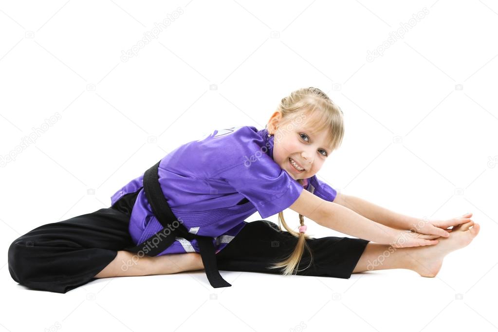 Little girl in kimono doing exercises