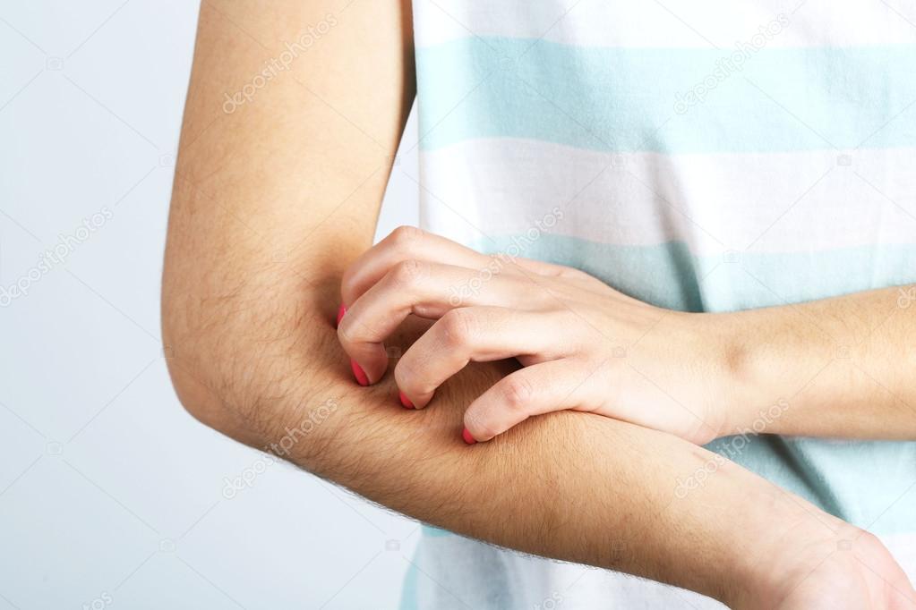 Woman has itch on gray background