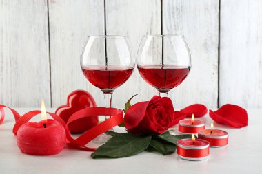 Cam, kırmızı gül ve dekoratif kalp renk ahşap arka plan üzerinde kırmızı şarap ile kompozisyon