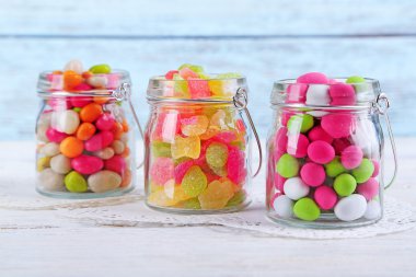 Cam Kavanoz renk ahşap arka plan üzerinde çok renkli şekerler