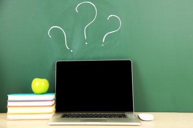 Masada yeşil yazı tahtası arka plan üstünde laptop