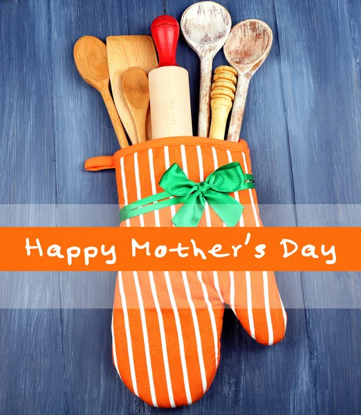 Verschillende keukengerei in pannenlap op houten achtergrond, Mother's Day wenskaart — Stockfoto