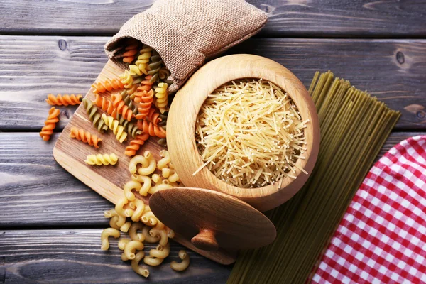 Different types of pasta in containers on wooden background — Stock Photo, Image