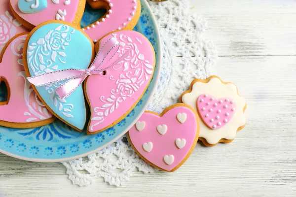 Cookies em forma de coração para dia dos namorados na placa, na cor de fundo de madeira — Fotografia de Stock