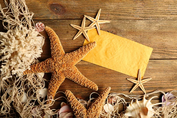 Card blank with sea stars and shells on wooden background — Stock Photo, Image