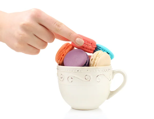 Ženská ruka s barevnými chutné macaroons z poháru izolovaných na bílém — Stock fotografie