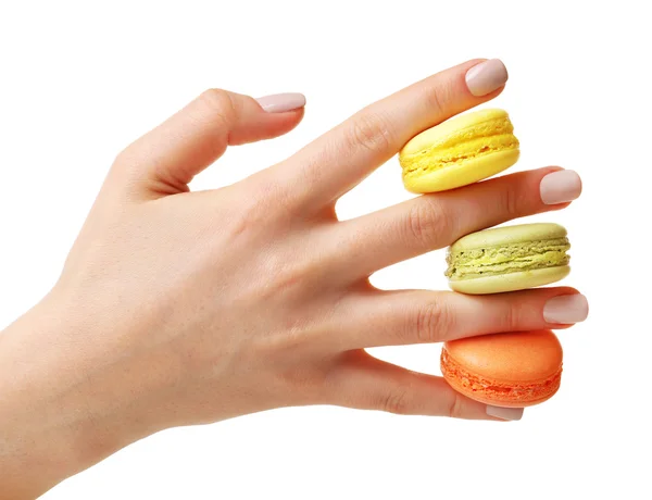 Mão feminina com saborosos macaroons coloridos isolados em branco — Fotografia de Stock