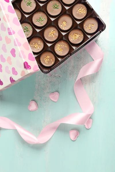 木製テーブルの上においしいチョコレート菓子とギフト ボックス — ストック写真