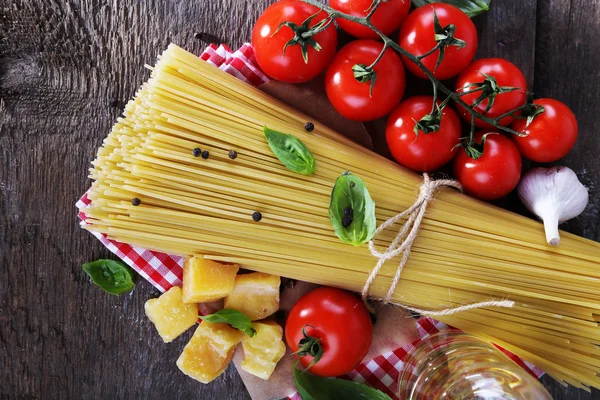 Pasta with cherry tomatoes and other ingredients on wooden table background — Stock Photo, Image