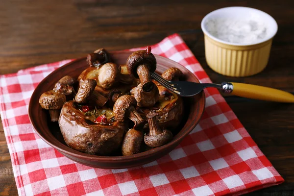 Baked potatoes with mushrooms in bowl and sauce on table close up — Stock Photo, Image