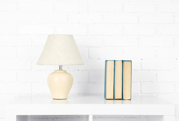 Houten plank met boeken en lamp — Stockfoto