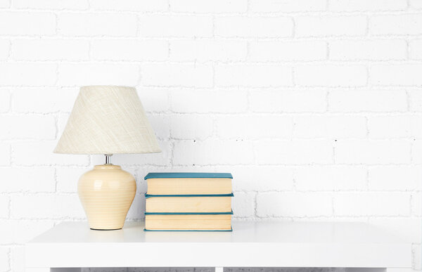 Wooden shelf with books and lamp