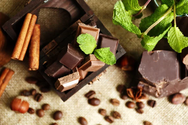 Stilleben med uppsättning av choklad på säckväv tyg, närbild — Stockfoto
