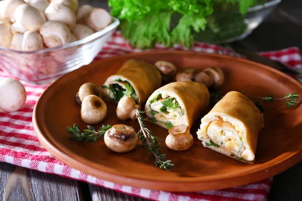 Frittelle con funghi cremosi in piatto su tavolo di legno, primo piano — Foto Stock