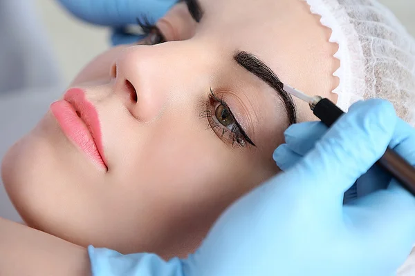 Cosmetologist applying permanent make — Stock Photo, Image