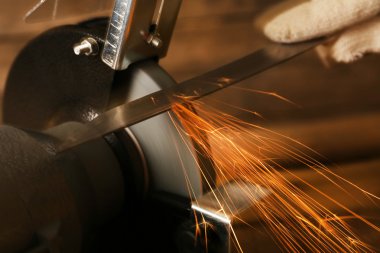 Bıçak bileyicisi ve bıçaklı bir el.