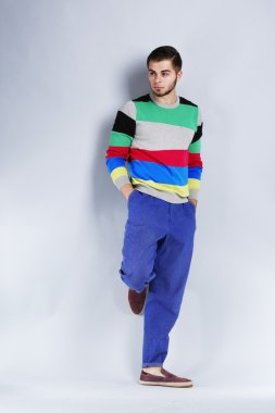 Gri arka plan üzerinde rahat tarzı genç adam