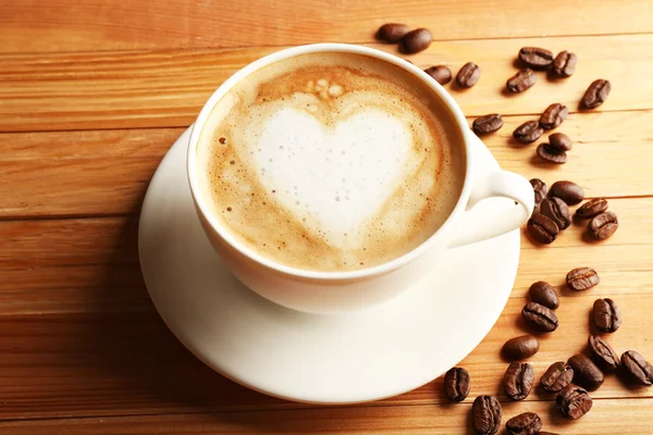 Cup of coffee latte art with grains — Stock Photo, Image