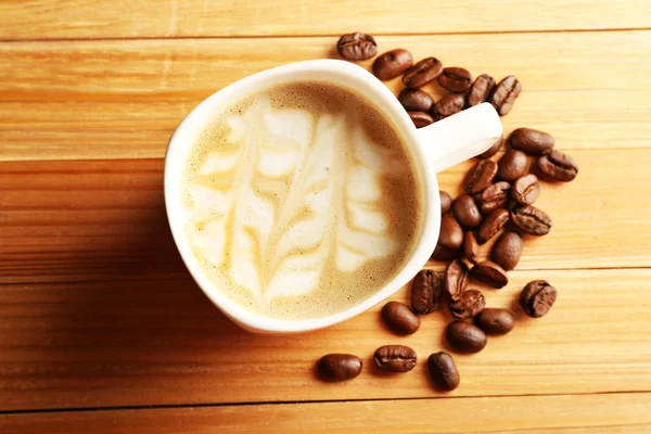 Tasse de café latte art avec des grains — Photo