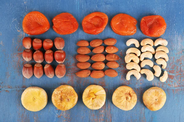 Gedroogde vruchten en noten op een houten achtergrond kleur — Stockfoto