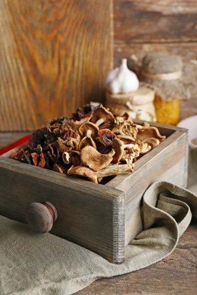 Dried mushrooms in crate on wooden background — Stock Photo, Image