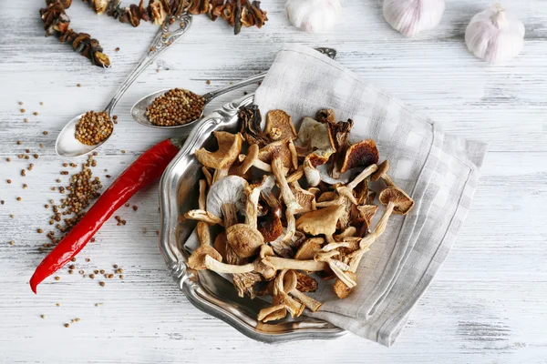 Gedroogde champignons in plaat met kruiden op houten tafel, bovenaanzicht — Stockfoto