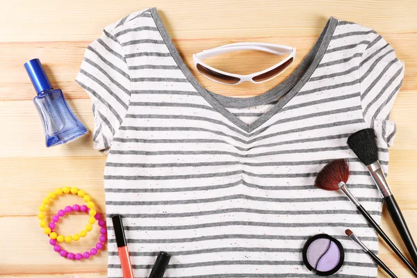 Camisa feminina e cosméticos na mesa de madeira, vista superior — Fotografia de Stock