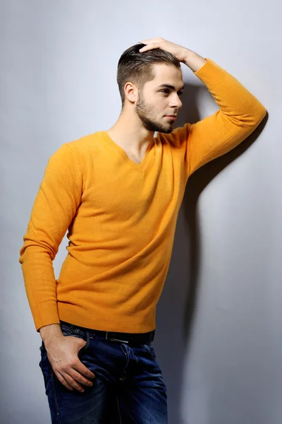 Portrait of young man on gray background — Stock Photo, Image