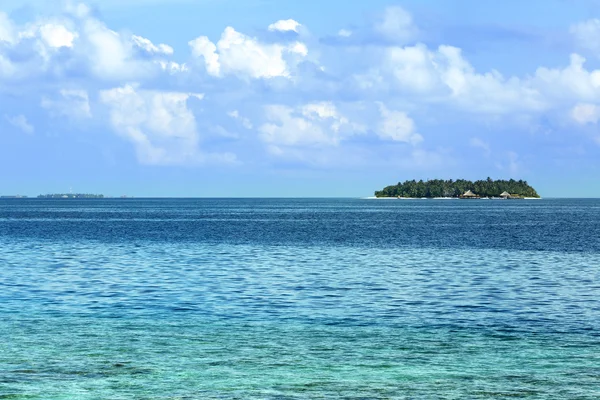 Vista de las hermosas aguas del océano azul y la isla en el horizonte en Baros Maldivas — Foto de Stock