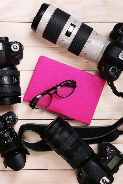 Moderne camera's op houten tafel — Stockfoto