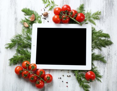 Taze otlar, domates ve baharat ile dijital tablet