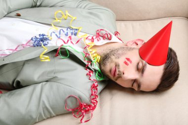 Genç adam eğlenceli kapattıktan sonra kanepede