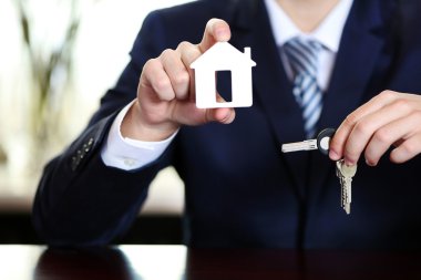 İşadamı ile anahtar taşı arka plan bulanık ofisi elinde