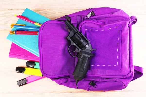 Gun in school backpack — Stock Photo, Image