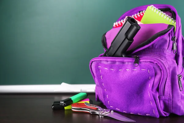 Arma na mochila da escola — Fotografia de Stock