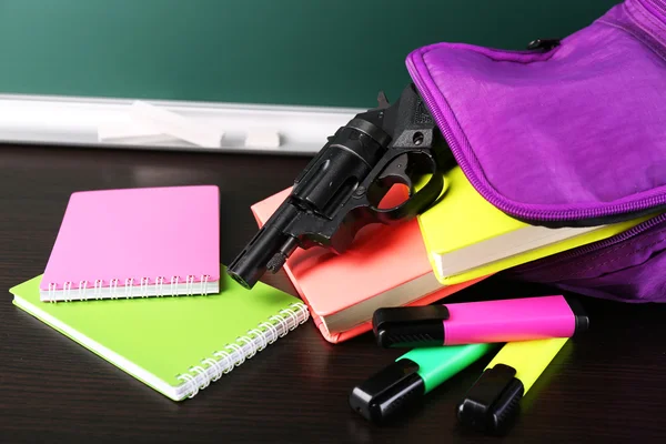 Arma na mochila da escola — Fotografia de Stock