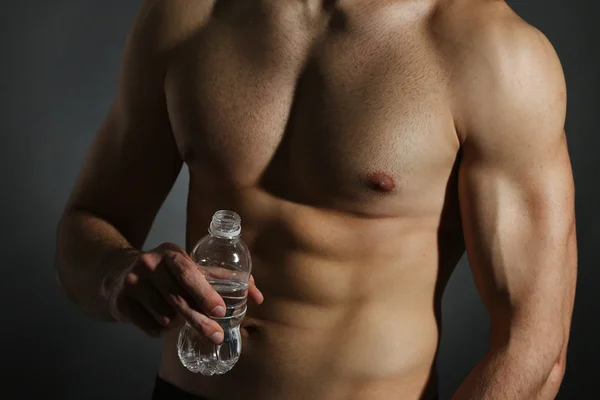 Muscle young man holding bottle of water — Stock Photo, Image