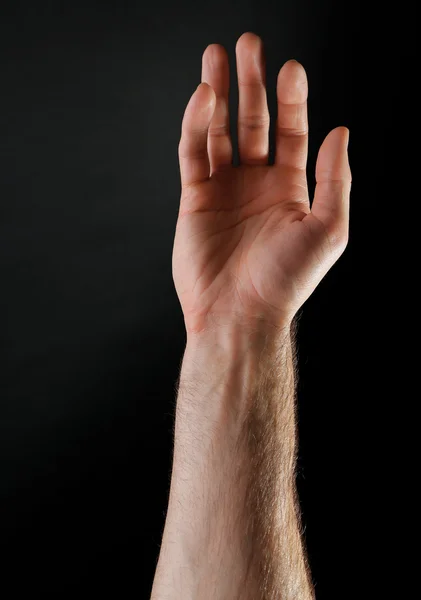 Męskiej ręki na ciemnym tle — Zdjęcie stockowe