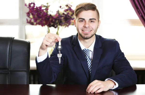 Portret van zakenman met sleutels in hand in office — Stockfoto